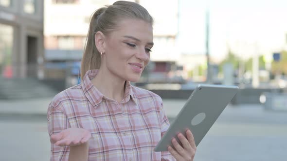 Video Call on Tablet By Young Woman Outdoor