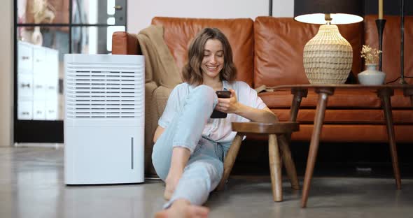 Woman with Air Purifier or Conditioner at Home