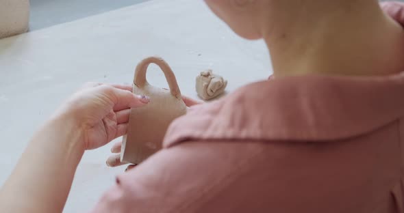 Female Potter Sitting and Makes a Cup at the Table. Woman Making Ceramic Item. Pottery Working