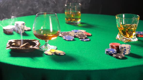 Dealing cards in a poker on table with a cigar and whiskey alt