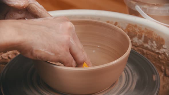 Pottery - Master Is Wiping the Bottom of the Bowl with a Yellow Sponge