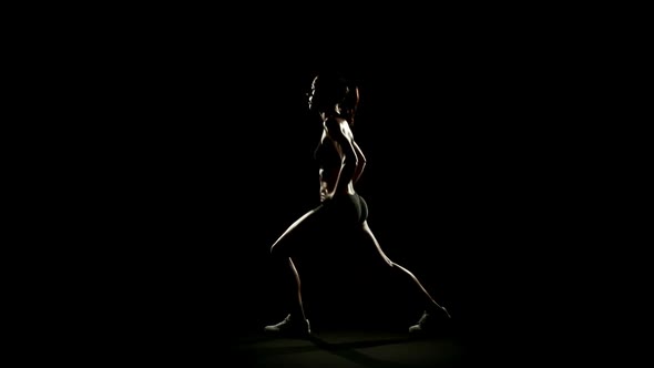 Young Athletic Woman Wearing Sporstwear is Exercising Isolated on Black