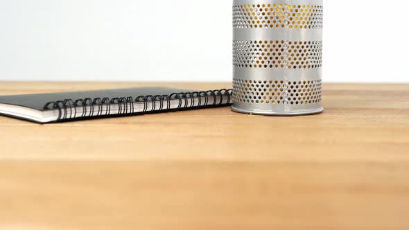 Close-up of pen holder with pencil and diary