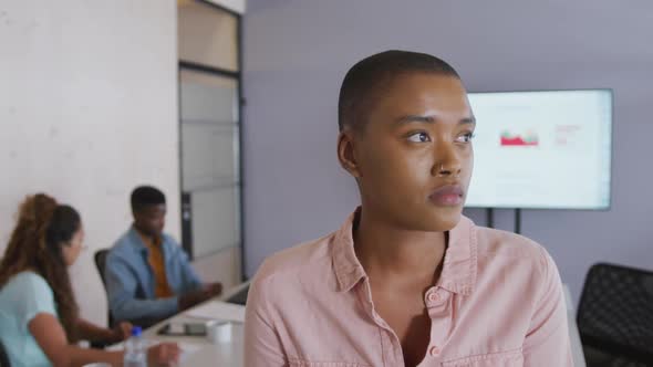 Portrait of smiling african american creative businesswoman at meeting, with diverse colleagues