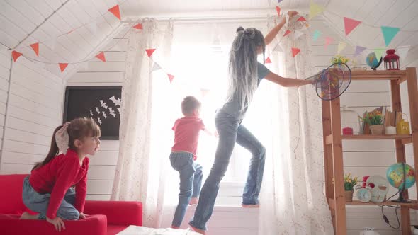 Children with Their Mother Decorate the Room for Halloween