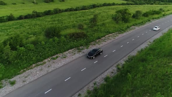 panorama of the mountain landscape. a black car is driving along the road.