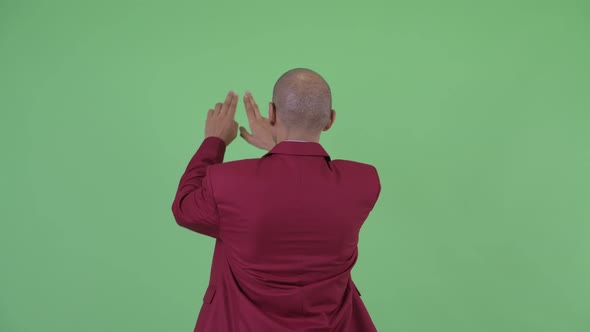 Rear View of Bald Multi Ethnic Businessman Touching Something