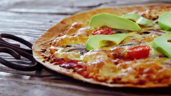 Baked pizza with sliced avocado toppings