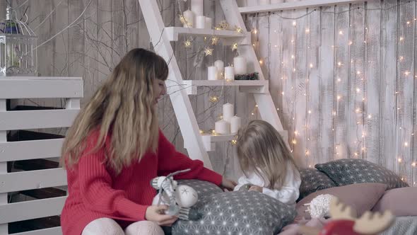 Mum in Red Dress Sweater Plays Toys with Toddler Girl