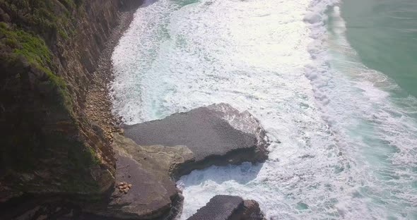 Spectacular aerial morning flight over waves moving into high cliffs, Australia