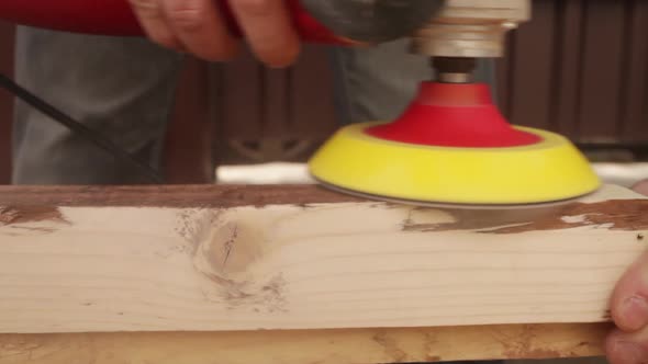 a Man Polishes the Boards with a Sandpaper and a Grinder Tool