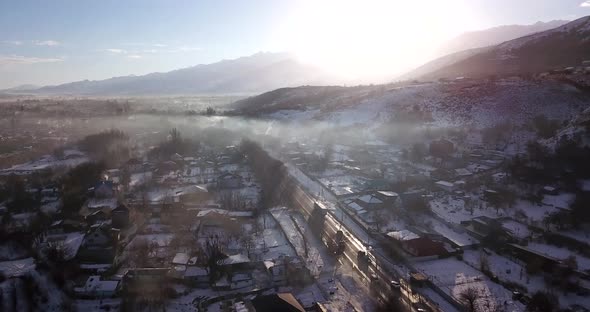 Winter Village and Highway with Cars in the Fog