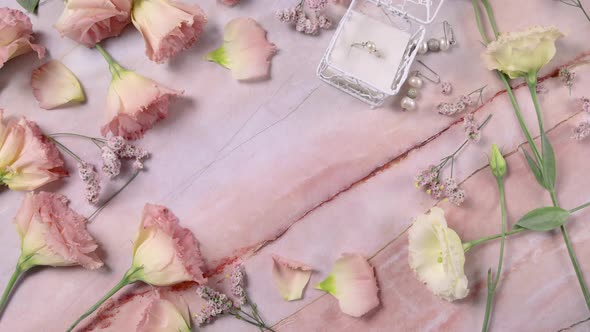 Hand puts LOVE card on a marble table near pink flowers close up