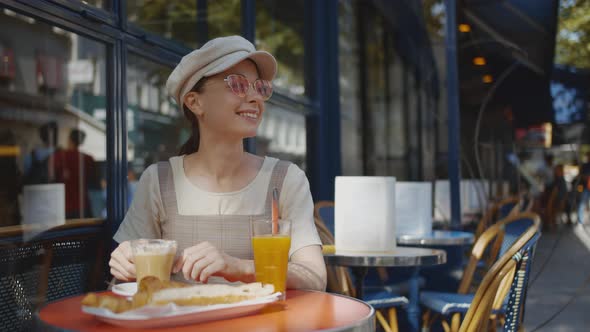 Smiling girl having breakfast in a cafe