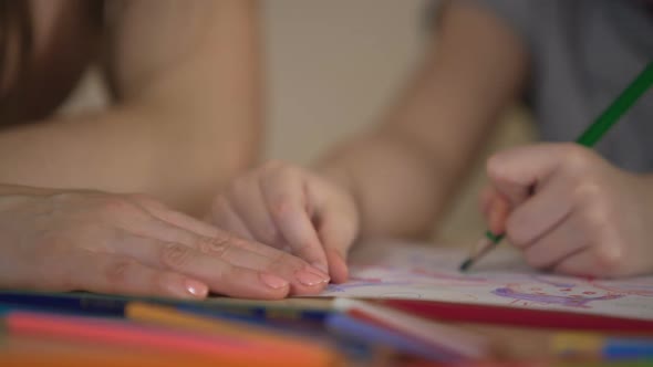 Hands of Parents and Child Drawing Together, Happy Family Having Fun Together