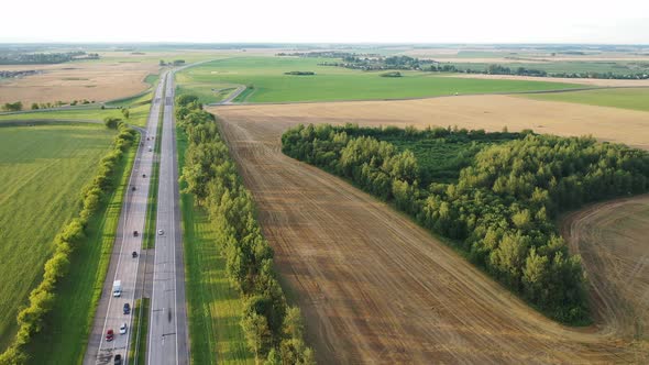 Top View of the Road with Cars and Fields Around the road.Fields and Trees Near the Highway with