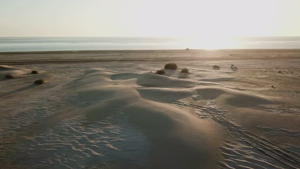 Two Cars Drive Through the Sands of a Lifeless Desert