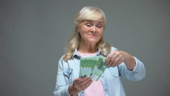 Cheerful Senior Female Throwing Euro Banknotes, Wasting Money, Loan Service