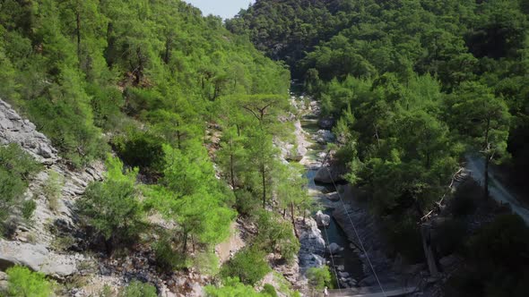 Aerial Landscape of Mountains and Ravine Among Them Where Wild River is Flowing