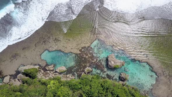 Aerial view of ocean waves at rock pool Magpupungko in Siargao, the Philippines. Camera flying down