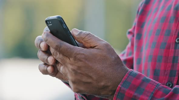 Closeup Focus on Smartphone in African American Male Hands