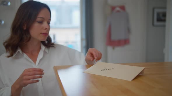 Young woman reading a letter in the apartment