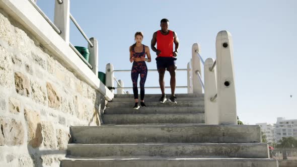 Couple jogging on a promenade at beach 4k