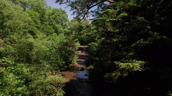 Aerial view of stone bridge over small river in the summer time