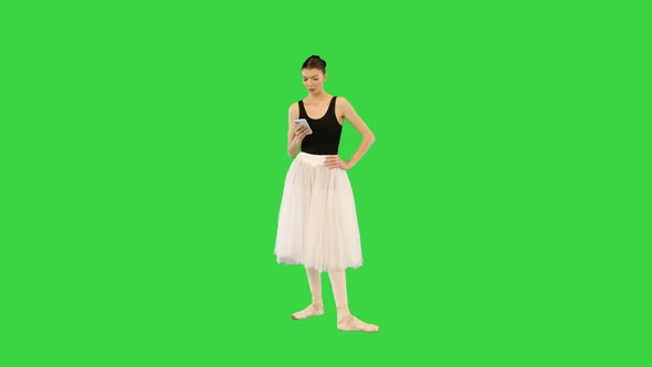 Tired Ballerina with Her Smartphone on the Break of Training on a Green Screen Chroma Key