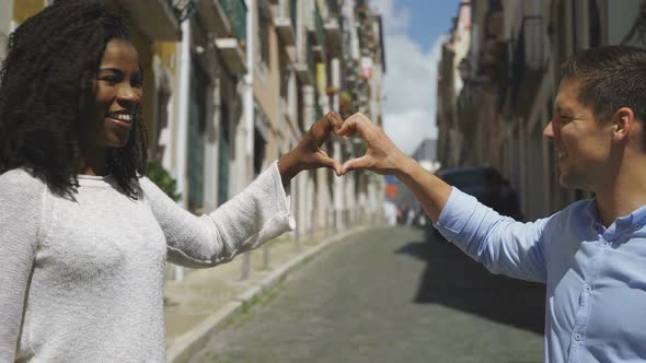 Smiling Young Couple Making Heart Shape with Hands