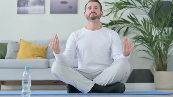 Close Up of Peaceful Man Meditating on Yoga Mat at Home