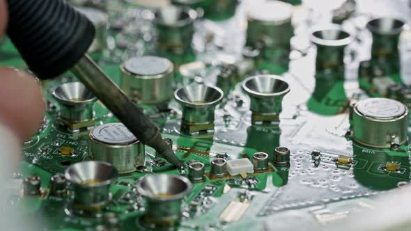 Close up of manual soldering of a large circuit board