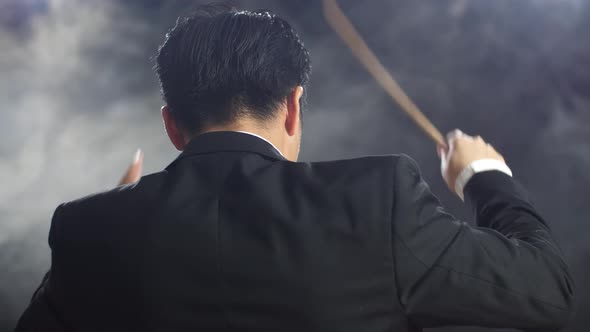 Close Up Back View Of Asian Conductor Man Holding A Baton And Showing Gesture Quickly