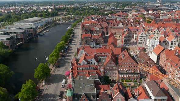 Aerial Sliding Footage of Historic Brick Town Houses Wide Riverside Street and Trave River