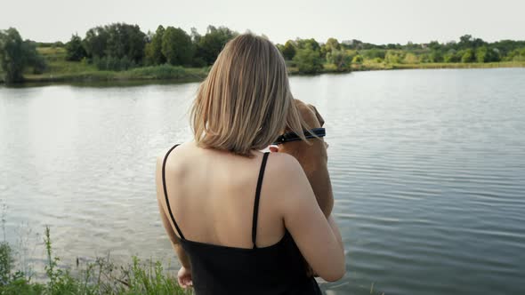 Portrait of Cute Small German Boxer Puppy in Nature Near the Lake Woman Holds Dog on Arms