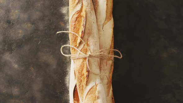 Video of baguettes tied with lace on a black surface