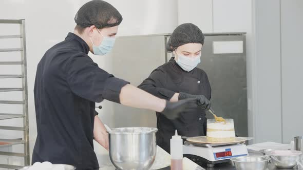 Side View of Professional Man Teaching Woman Cooking Dessert in Commercial Kitchen