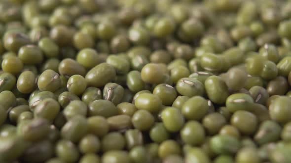 Green Asian Mung beans fall in a pile close up.