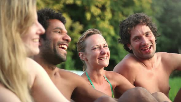 Four friends laughing while sitting in nature