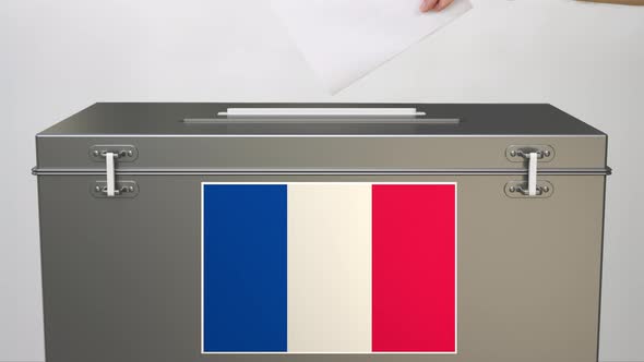 Hand Putting Paper Ballot Into Ballot Box with Flag of France