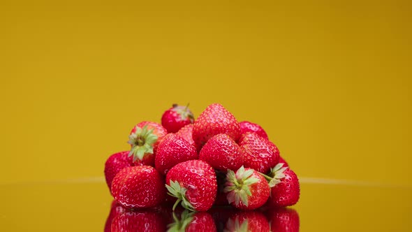 Closeup of Rotating Ripe Red Strawberry Isolated on Yellow Background Making Jam of Fruits and