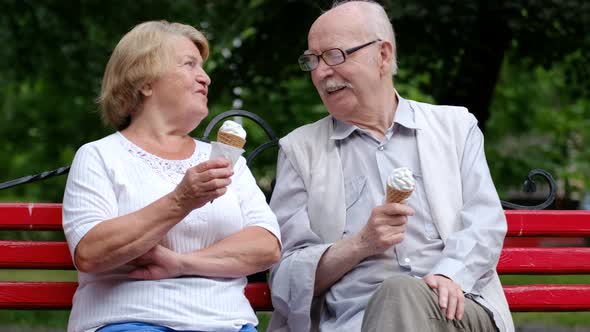 An Old Married Couple Eats Ice Cream and Communicates with Each Other They are Resting in a Park