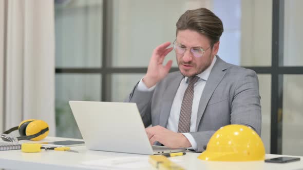 Middle Aged Engineer having Neck Pain while using Laptop in Office