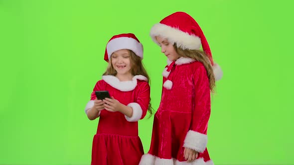 Two Children in New Year Costumes Do Selfie on the Phone. Green Screen