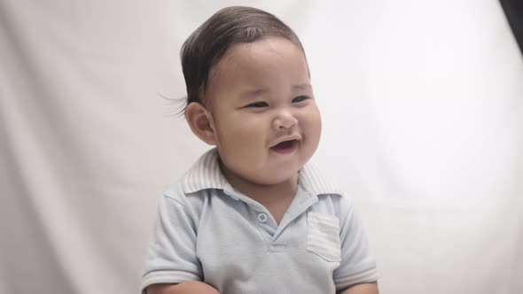 Cheerful Baby Boy With Chubby Cheeks Smiling. medium shot