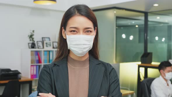 Portrait of Asian business woman working in office with new normal social distancing lifestyle.