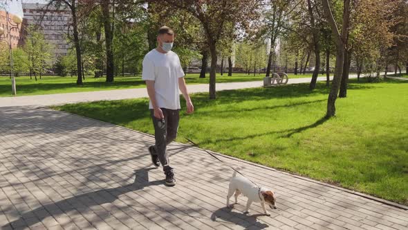 Man in Face Mask Walking Cute Dog in Park