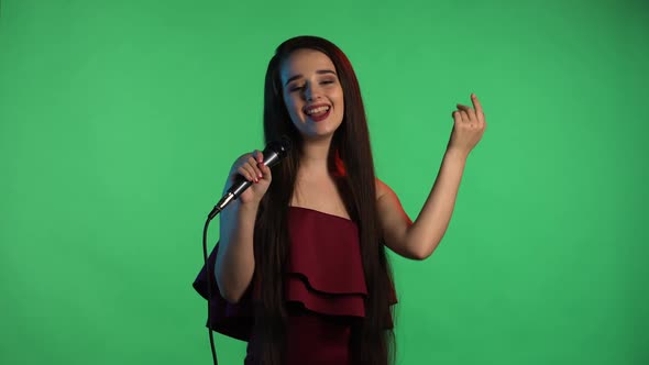 Portrait of Beautiful Young Woman Illuminated By Blue Neon Light Sings Song Into Microphone