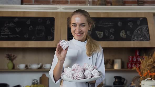 Beautiful Female Baker Smiling to the Camera with a Plate of Marshmallows