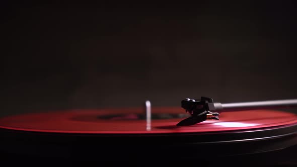 vinyl player. pink plate. Black background. vintage